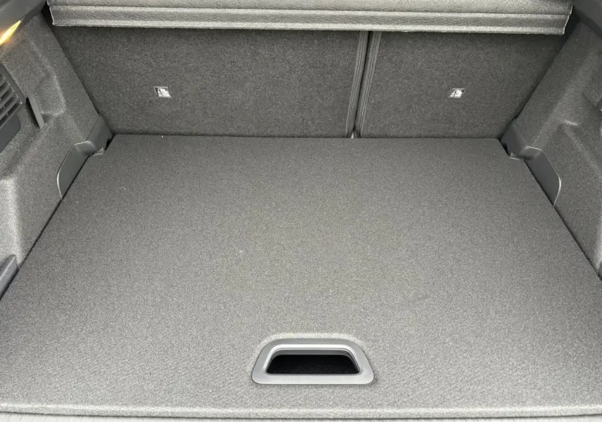 Coffre ouvert vu de dessus de la Citroën C4 gris acier, montrant la surface de chargement plate et le cache-bagages.
