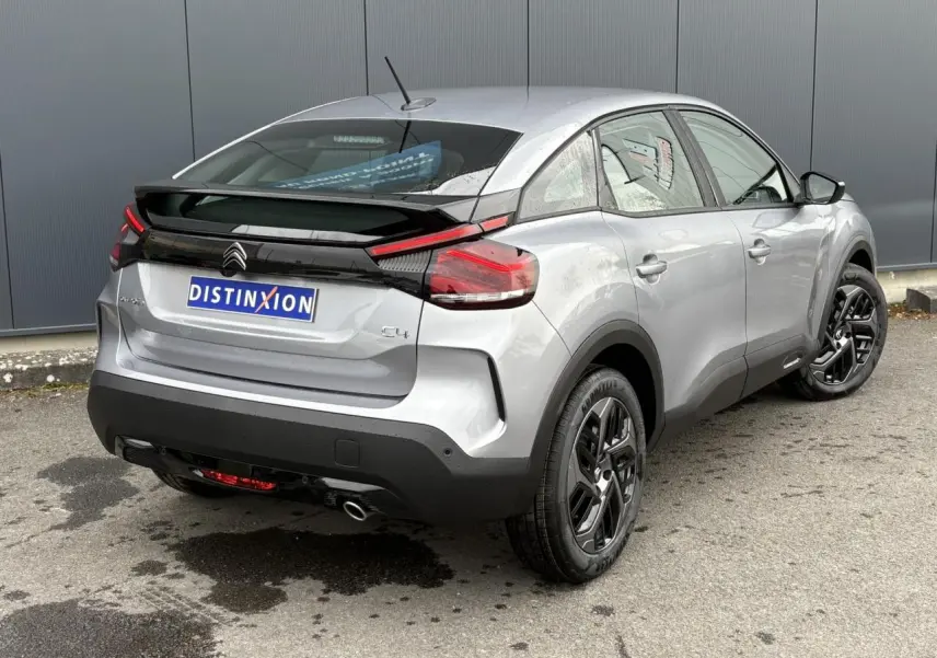 Vue 3/4 arrière droite d'une Citroën C4 gris acier avec jantes alliage noires et feux arrière LED distinctifs.