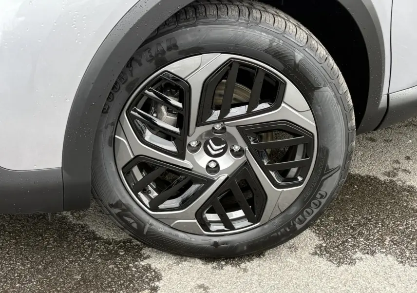 Gros plan sur la roue avant droite de la Citroën C4 gris acier, avec jante alliage diamantée noire et pneu Goodyear.