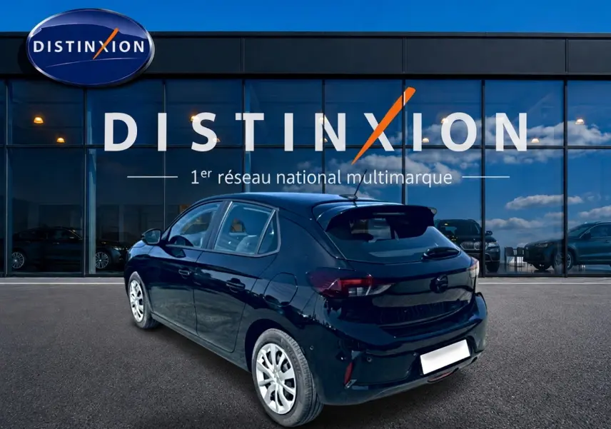 Opel Corsa noire vue 3/4 arrière droit, avec becquet et feux arrière LED, devant vitrine Distinxion.