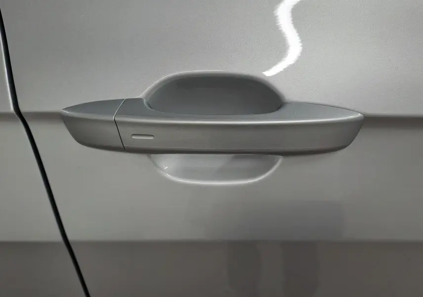 Poignée de porte côté gauche du Volkswagen T-Cross 2025 en peinture métallisée Reflet d'argent.