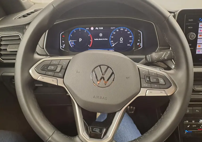 Vue rapprochée du volant multifonction noir du Volkswagen T-Cross 2025 avec tableau de bord numérique allumé.