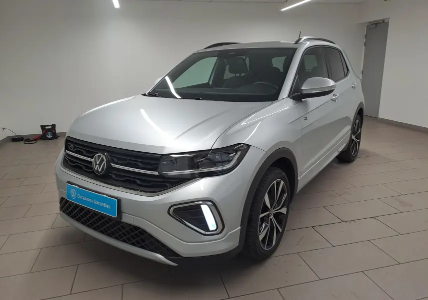 Volkswagen T-Cross 2025 en Reflet d'argent, vue 3/4 avant droit avec jantes alliage et feux LED allumés.
