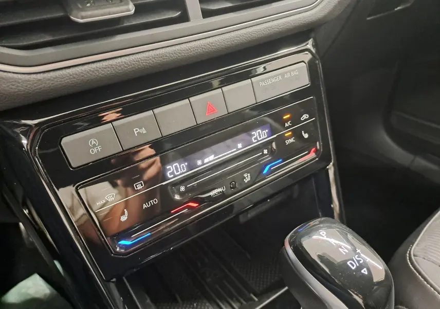 Gros plan sur la console centrale du Volkswagen T-Cross 2025 avec climatisation digitale et levier de vitesses automatique.