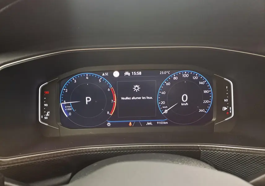 Tableau de bord numérique du Volkswagen T-Cross 2025 affichant la vitesse à 0 km/h et l'indication d'allumer les feux.