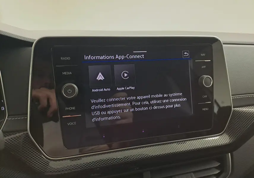 Écran tactile central du Volkswagen T-Cross 2025 affichant les options Android Auto et Apple CarPlay, entouré de commandes.