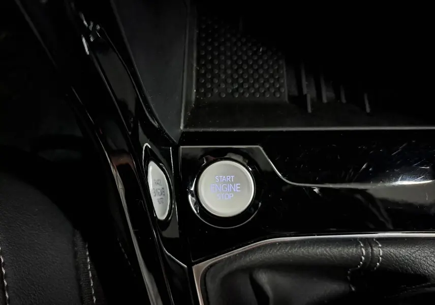 Bouton start engine stop en gros plan sur la console centrale noire brillante du Volkswagen T-Cross 2025 finition R-Line Edition