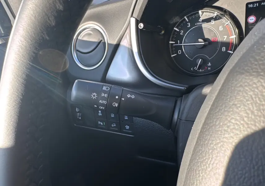 Vue rapprochée du tableau de bord et du volant du Suzuki Vitara 2025, avec commandes d'éclairage et compte-tours visibles.