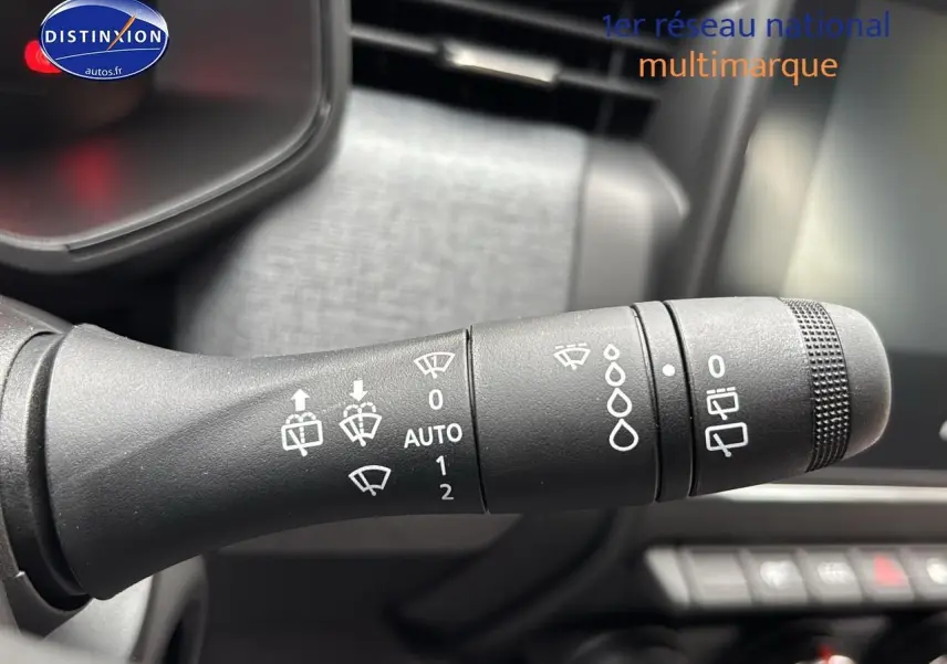 Gros plan sur la commande d’essuie-glace du côté gauche dans l’habitacle d’une Renault Clio V noire.