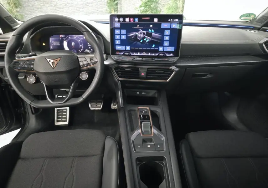 Vue intérieure avant de la CUPRA Leon 2025 gris, volant Supersports, écran tactile HD et console centrale moderne.