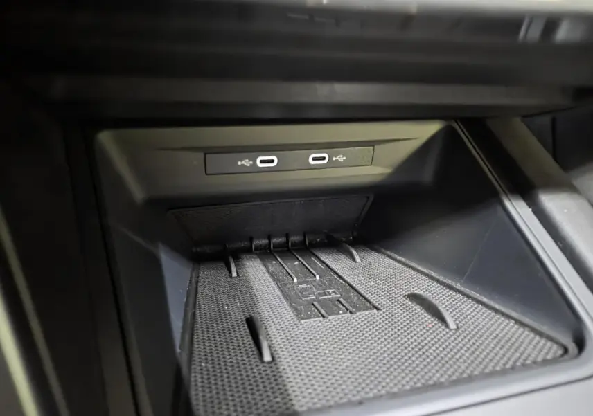 Gros plan sur la console centrale noire avec deux prises USB-C éclairées dans une CUPRA Leon gris 2025.