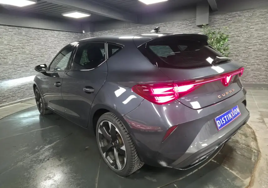 Vue 3/4 arrière droite d'une CUPRA Leon gris magnétique avec feux arrière Tri-LED et jantes alliage 18 pouces.