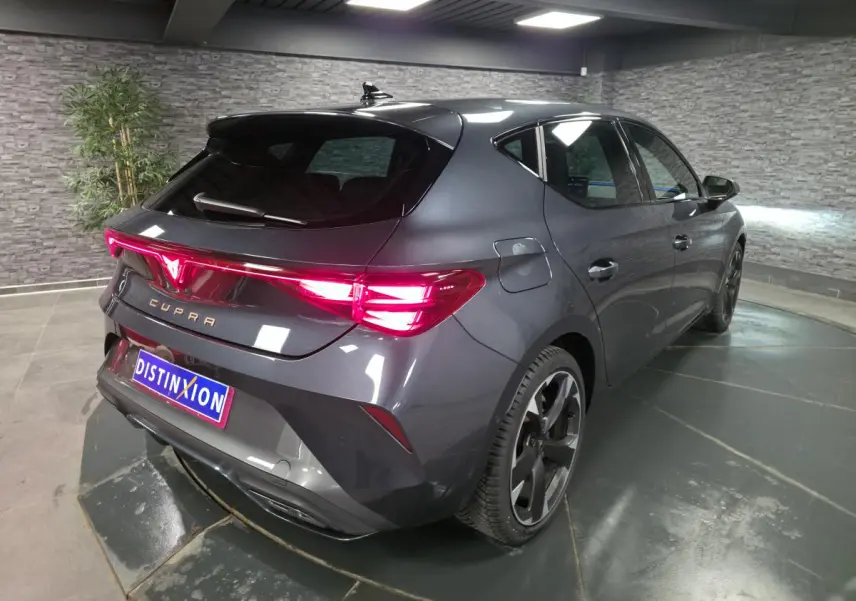 Vue 3/4 arrière droite d'une CUPRA Leon gris magnétique avec feux arrière Tri-LED et jantes alliage 18 pouces.