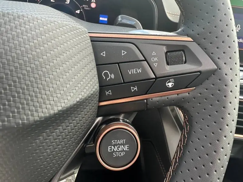 Détail du volant perforé côté droit avec commandes et bouton Start Engine Stop du CUPRA Formentor gris Graphène 2025.
