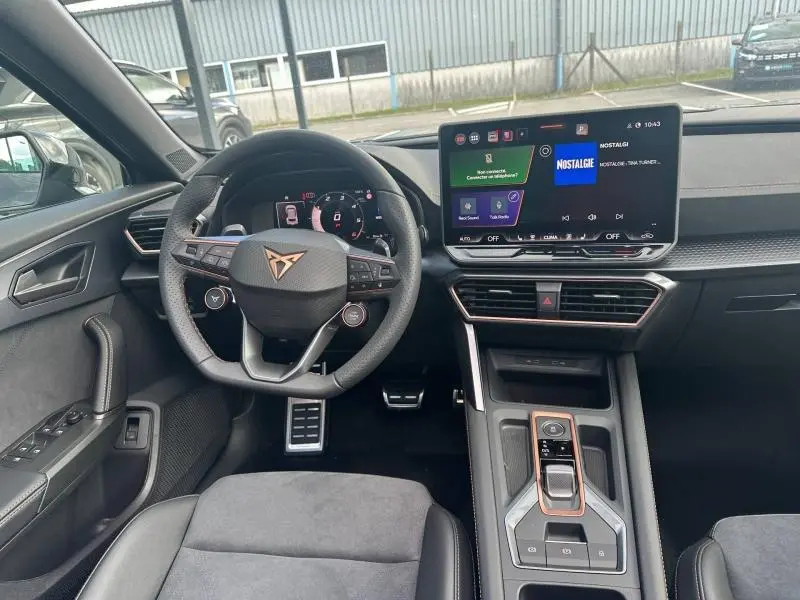 Vue intérieure centrée sur le poste de conduite du CUPRA Formentor 2025, avec volant multifonction et écran tactile moderne.