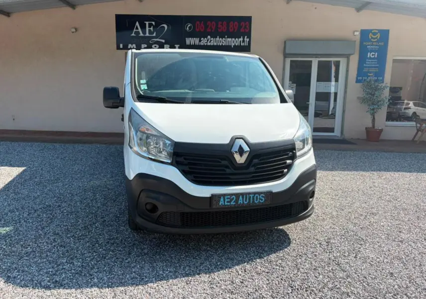 Vue de face d’un Renault Trafic Fourgon blanc de 2018, avec calandre noire et plaque AE2 AUTOS visible.