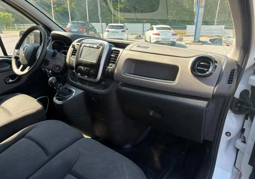 Intérieur du Renault Trafic Fourgon blanc 2018, vue côté passager montrant tableau de bord et volant à gauche.