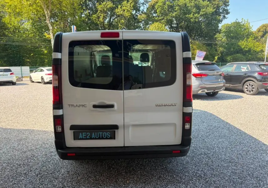 Vue arrière d’un Renault Trafic Fourgon blanc de 2018, avec portes battantes et vitres teintées.