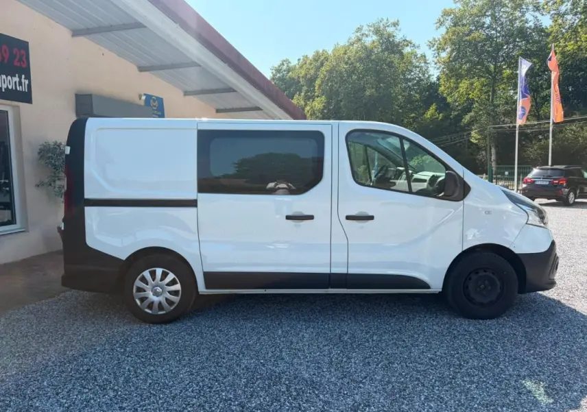 Profil droit du Renault Trafic Fourgon blanc de 2018, version Grand Confort L1H1, avec fenêtres latérales teintées.