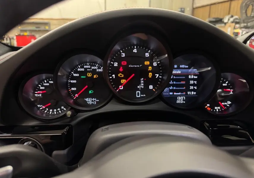 Vue rapprochée du tableau de bord de la Porsche 911 Carrera T 2018, affichage digital et compte-tours central.