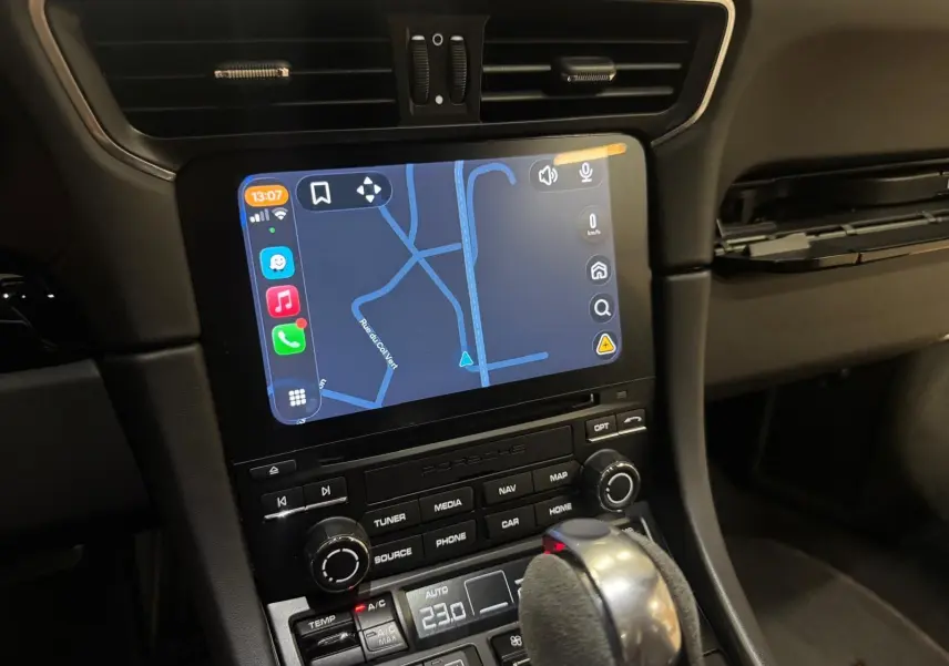 Vue rapprochée de la console centrale de la Porsche 911 991.2 Carrera T gris GT Silver avec écran tactile et levier PDK en alcantara.
