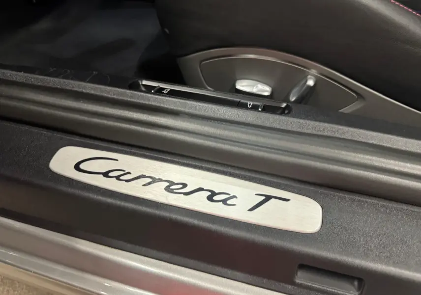 Gros plan sur la plaque de seuil de porte "Carrera T" à l'intérieur d'une Porsche 911 gris GT Silver.