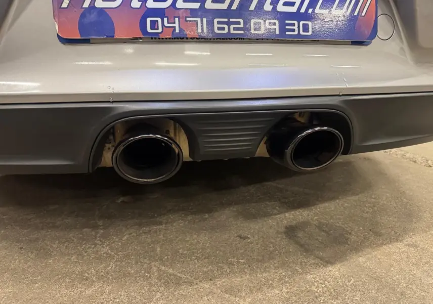 Gros plan sur la double sortie d’échappement noire d’une Porsche 911 991 2 Carrera T gris GT Silver, vue arrière basse.