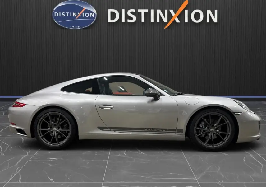 Porsche 911 991.2 Carrera T gris GT Silver vue profil droit, jantes Carrera S noires et bande latérale distinctive.