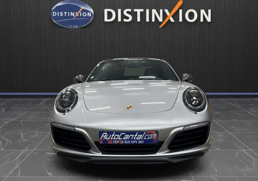 Vue frontale d'une Porsche 911 991 2 Carrera T 2018 en gris GT Silver, avec phares ronds et calandre noire.
