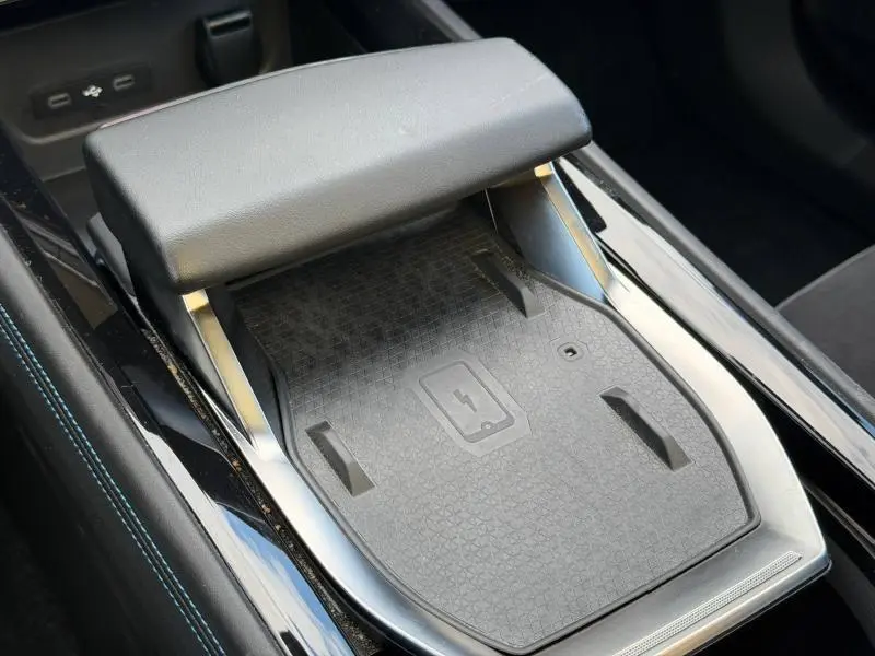 Détail de la console centrale noire avec chargeur sans fil et accoudoir en cuir dans la Renault Rafale 2025.