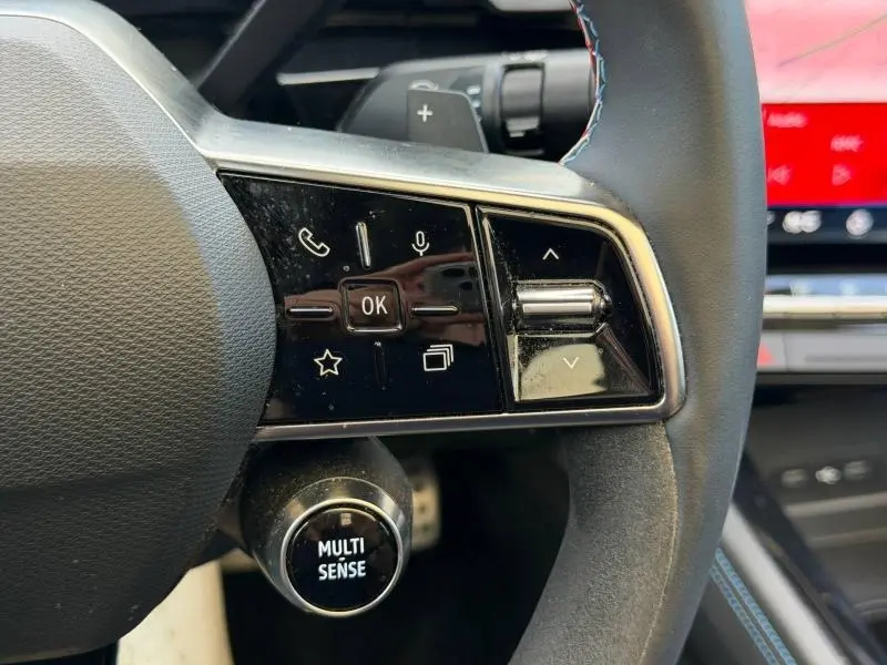 Gros plan sur les commandes au volant côté gauche du Renault Rafale noir étoilé, avec bouton Multi Sense visible en dessous.