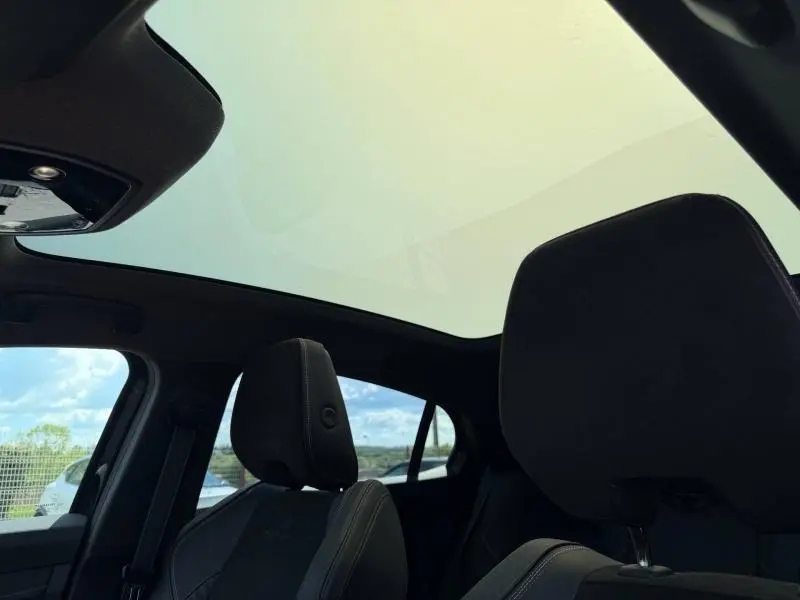Vue intérieure du toit panoramique et des sièges avant noirs de la Renault Rafale 2025 esprit Alpine.