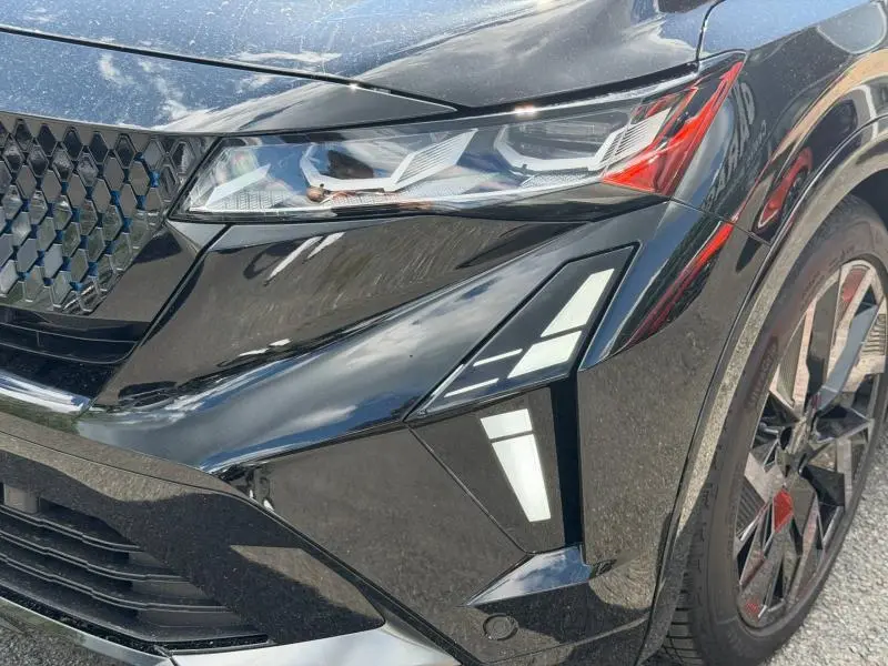Gros plan sur l'avant droit noir étoilé métallisé du Renault Rafale 2025, mettant en valeur le phare LED et la jante alu sport.