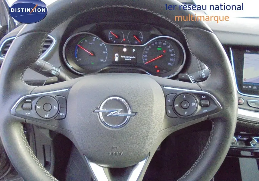 Vue rapprochée du volant en cuir noir avec commandes intégrées de l’Opel Grandland X gris Moai Metal, tableau de bord visible.