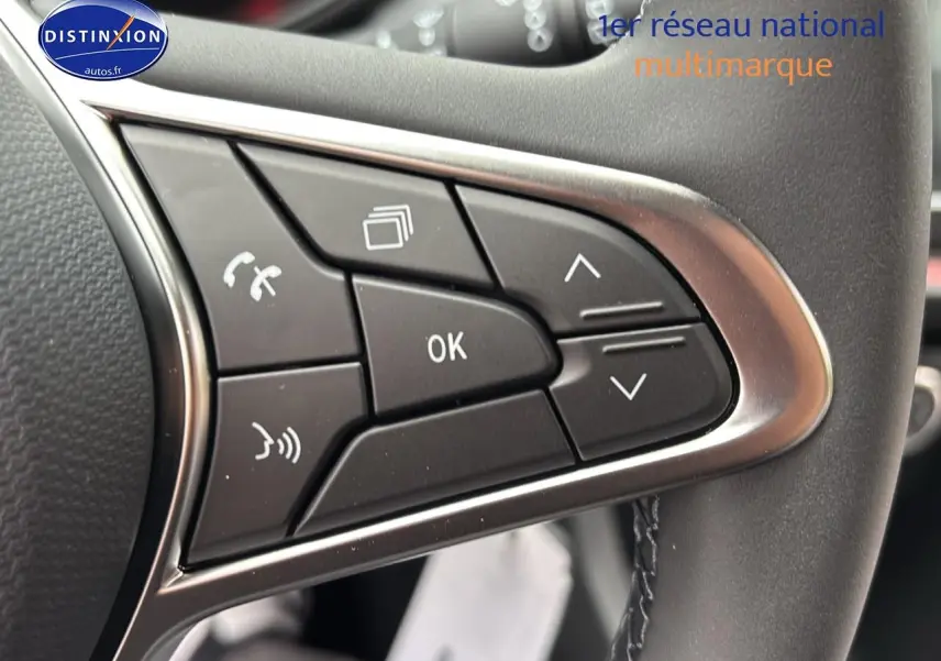 Gros plan sur les commandes multifonctions noires du volant d'une Renault Clio V noire, côté gauche.