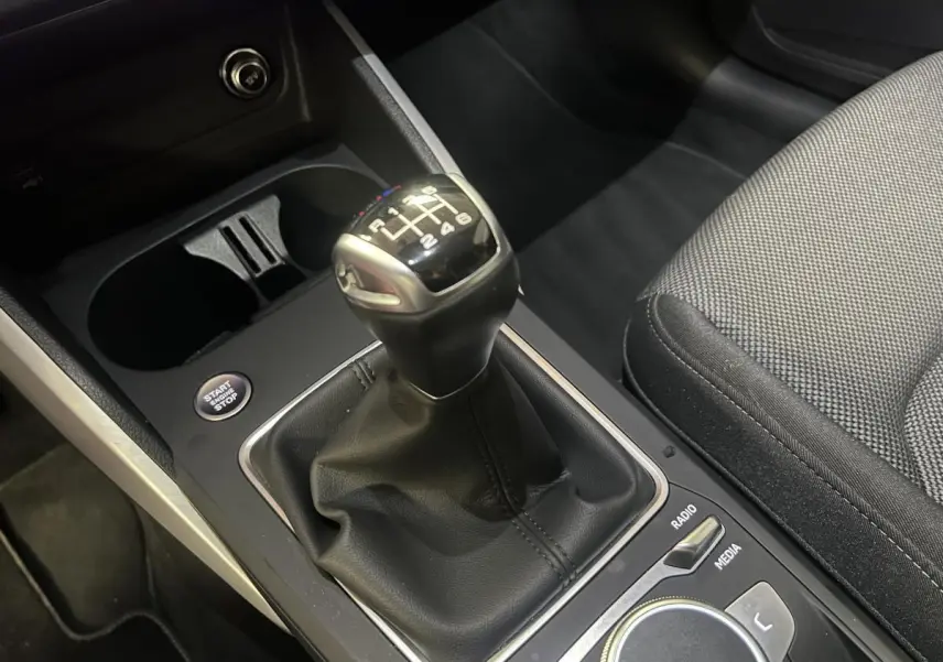 Gros plan sur levier de vitesses manuel noir et console centrale de l'Audi Q2 S line 2024.