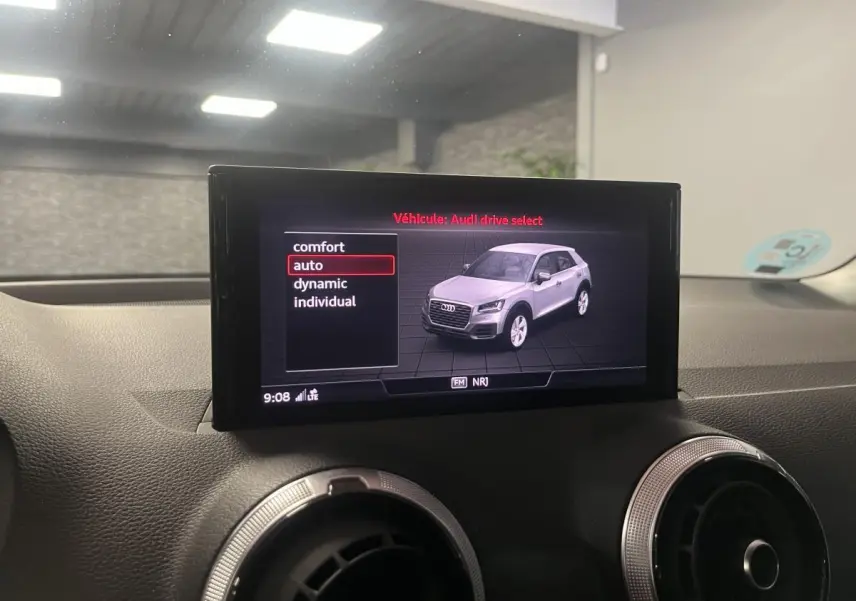 Écran intérieur affichant le mode Audi Drive Select avec une image 3/4 avant d'un Audi Q2 gris clair.