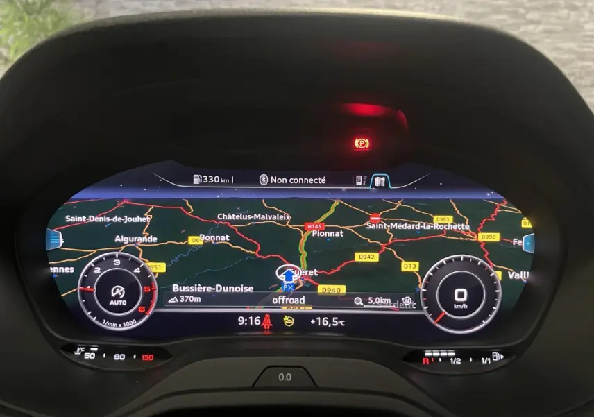 Affichage numérique du tableau de bord Audi Q2 2024 avec navigation et compte-tours, vue frontale rapprochée.