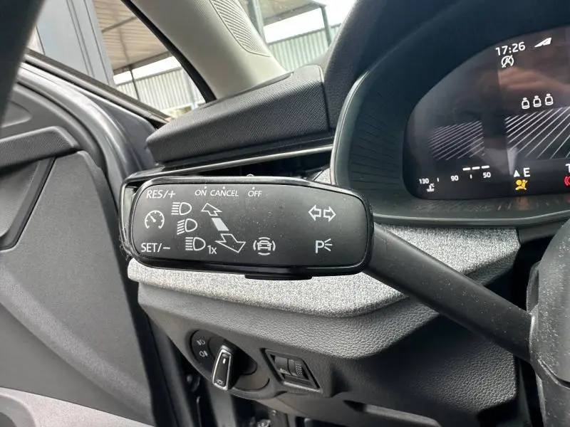 Gros plan sur la commande multifonction noire à gauche du volant dans l’habitacle gris graphite métallisé d’une Skoda Scala 2025.