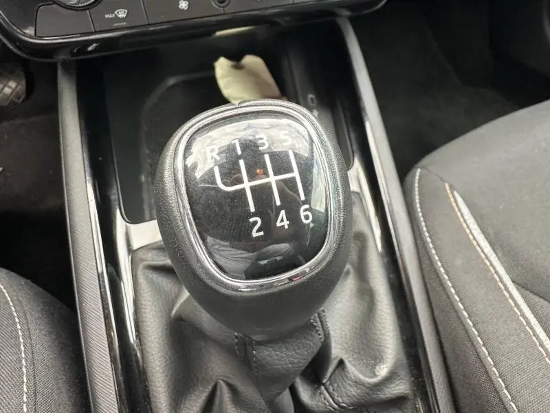 Gros plan sur le pommeau de levier de vitesses manuel noir de la Skoda Scala 1.0 TSI Evo2, intérieur tissu gris.