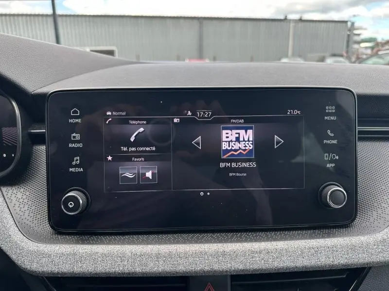 Écran tactile central de la Skoda Scala 2025 affichant la radio BFM Business, entouré de commandes multimédia.