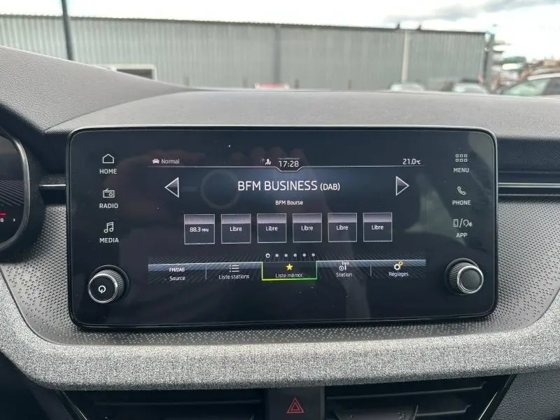 Écran tactile central du tableau de bord de la Skoda Scala gris graphite, affichant la radio BFM Business.