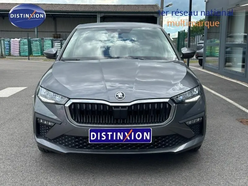 Vue avant d'une Skoda Scala gris graphite métallisé avec calandre chromée et phares LED, sur parking extérieur.