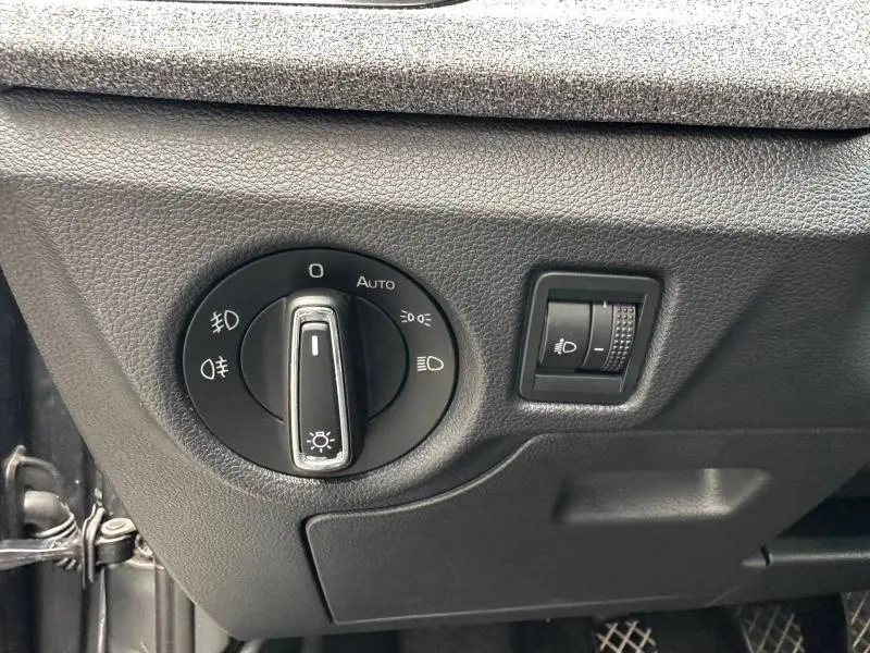 Gros plan sur le bouton de commande des phares et réglage d’intensité dans l’habitacle gris d’une Skoda Scala 2025.