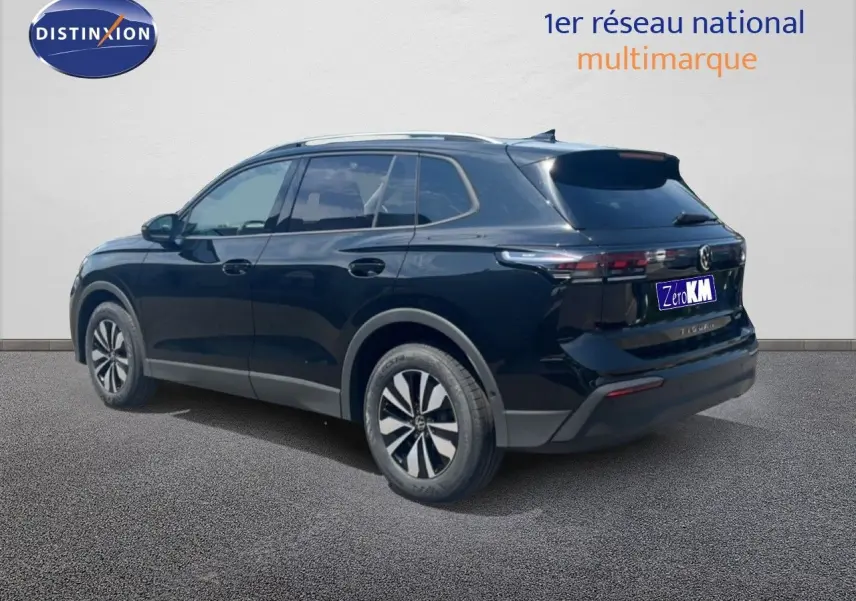 Volkswagen Tiguan noir grenadilla métal vu en 3/4 arrière côté droit, avec jantes alliage et toit argenté.
