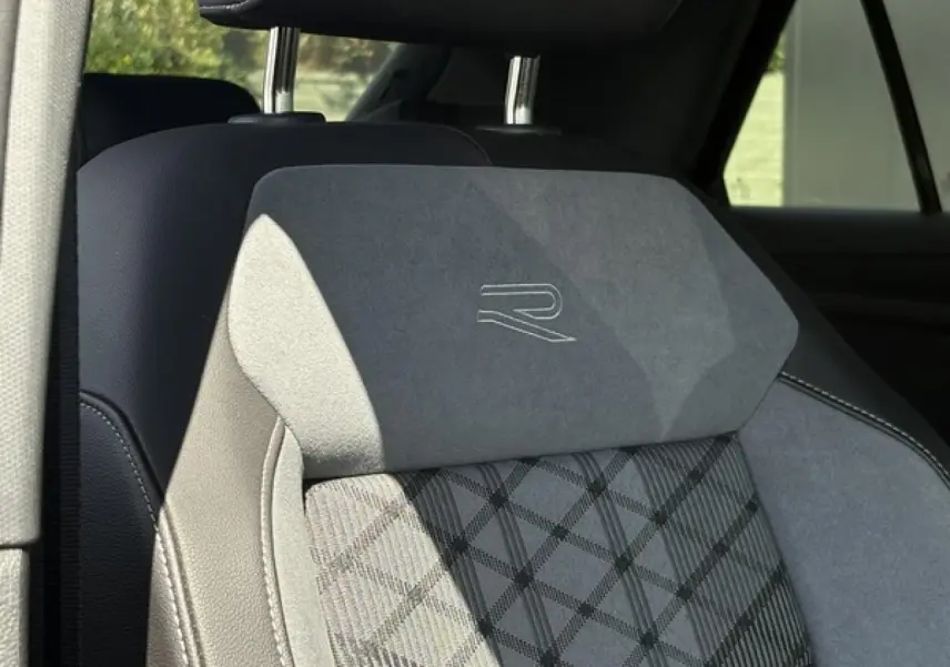 Gros plan sur le siège avant en cuir et alcantara gris avec logo R-Line brodé, intérieur du Volkswagen T-Roc 2025.