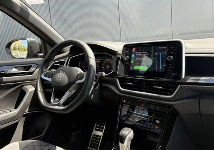 Vue intérieure côté conducteur du Volkswagen T-Roc 1.5 TSI R-Line 2025, avec volant cuir multifonction et écran tactile central.