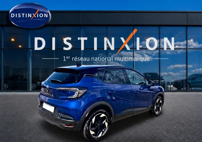 Vue 3/4 arrière droite d’un Renault Captur 2026 bleu iron avec toit noir, jantes alu et feux arrière LED distinctifs.