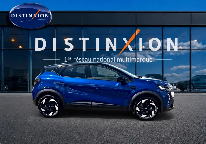 Renault Captur 2026 bleu iron toit noir, vue de profil côté gauche devant vitrine Distinxion.