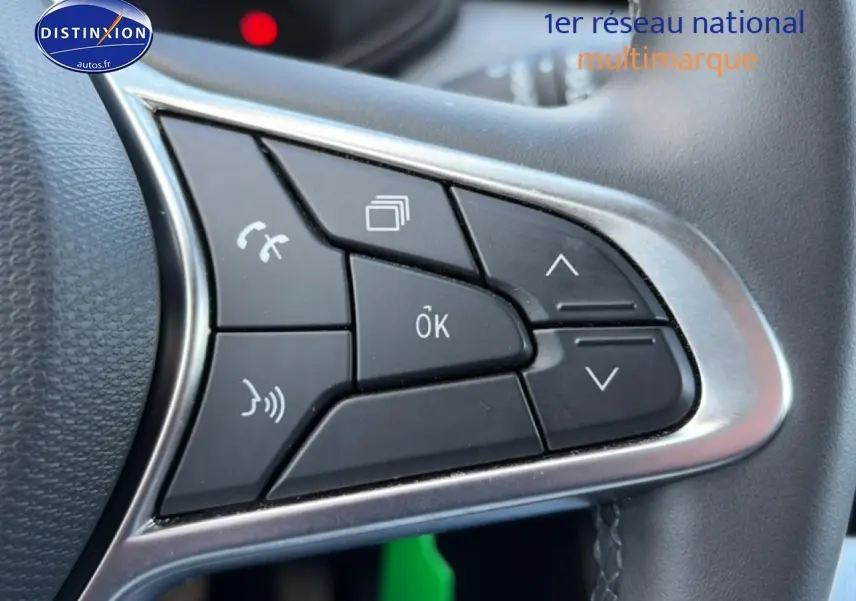 Gros plan sur les commandes multifonctions noires du volant de la Renault Clio V gris métal, avec contour argenté.